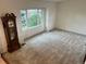Bright living room with large window, neutral carpet, and classic grandfather clock at 7906 W Walker Dr, Littleton, CO 80123