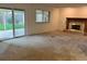 Empty living room featuring carpeting, a fireplace, and a sliding glass door leading to a patio at 7906 W Walker Dr, Littleton, CO 80123