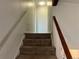 Carpeted staircase with white and wooden railing at 7906 W Walker Dr, Littleton, CO 80123