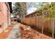Backyard featuring mulched beds, gravel pathway and wood fencing at 2568 Clermont St, Denver, CO 80207