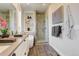 Modern bathroom featuring a glass-enclosed shower, soaking tub, stylish fixtures, and sleek gray wood-look tile flooring at 2568 Clermont St, Denver, CO 80207