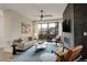Bright living room featuring a brick fireplace, ceiling fan, and access to an outdoor patio at 2568 Clermont St, Denver, CO 80207