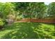 Expansive backyard with lush green lawn, mature trees providing shade, and a charming deck, all enclosed by a wooden fence at 16438 E Prentice Cir, Centennial, CO 80015