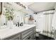 Modern bathroom with a sleek gray vanity, white countertop and walk-in shower with framed glass door at 16438 E Prentice Cir, Centennial, CO 80015