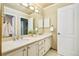 Bright bathroom features a double sink vanity with neutral countertop and a white door for linen and storage at 16438 E Prentice Cir, Centennial, CO 80015