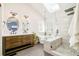 Bright bathroom featuring a skylight, a soaking tub, dual vanities, and a modern shower at 16438 E Prentice Cir, Centennial, CO 80015
