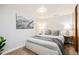 This stylish bedroom features neutral colors, soft throw blanket, mountain art, and ambient lighting at 16438 E Prentice Cir, Centennial, CO 80015