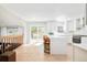Modern kitchen with hardwood floors, white cabinetry, island with seating, and sliding doors to the deck at 16438 E Prentice Cir, Centennial, CO 80015