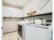 Well-organized laundry room with bright white washer and dryer and ample storage in the white cabinets at 16438 E Prentice Cir, Centennial, CO 80015