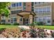 Exterior view of building entrance with covered walkway, flowers, and manicured lawn at 745 S Alton Way # 11A, Denver, CO 80247
