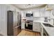 Bright kitchen featuring stainless steel appliances, white cabinetry, and tiled backsplash at 745 S Alton Way # 11A, Denver, CO 80247