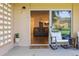 Inviting outdoor patio with rocking chairs and a glimpse of the well-lit living room with hardwood floors at 745 S Alton Way # 11A, Denver, CO 80247