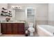 Bathroom with a marble countertop, modern fixtures, a bathtub, shelving, and a toilet at 3761 S Orleans St, Aurora, CO 80013