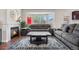 Cozy living room with a fireplace, large bay window, hardwood floors, and a comfortable gray sectional at 3761 S Orleans St, Aurora, CO 80013