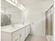 Bathroom features a double sink vanity, a large mirror, and a glass-enclosed shower at 17417 E 89Th Way, Commerce City, CO 80022