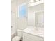 Clean bathroom featuring white tiles, a large mirror, and bright natural light at 17417 E 89Th Way, Commerce City, CO 80022