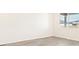 A bright bedroom has gray vinyl flooring and white walls with a large window at 17417 E 89Th Way, Commerce City, CO 80022