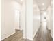 Hallway with light colored walls and wood-look floors provides ample lighting and access to rooms at 17417 E 89Th Way, Commerce City, CO 80022