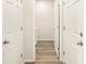 Hallway showing entry to the laundry room, clean white walls, and wood-look floors at 17417 E 89Th Way, Commerce City, CO 80022