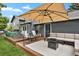 Outdoor patio with a large umbrella, ample seating, and a built in fire pit at 5870 S Perth Pl, Centennial, CO 80015