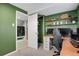 A home office with green walls, floating shelves, and a view to the laundry room at 5870 S Perth Pl, Centennial, CO 80015