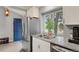 Bright kitchen with a stainless steel refrigerator, double sink with granite countertop, and a view of the front door at 5870 S Perth Pl, Centennial, CO 80015