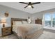 Comfortable main bedroom featuring a wooden bed frame, side tables, and a bright window with outdoor views at 5870 S Perth Pl, Centennial, CO 80015