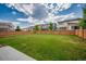 Expansive backyard with a well-maintained lawn, wooden privacy fence, and shade trees at 10071 Yampa Ct, Commerce City, CO 80022
