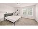 Minimalist bedroom with modern furnishings, light-filled windows, and neutral carpeting at 10071 Yampa Ct, Commerce City, CO 80022