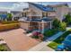 Beautiful two-story home featuring solar panels, a brick driveway, and colorful landscaping at 10071 Yampa Ct, Commerce City, CO 80022