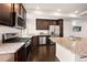 Well-equipped kitchen featuring stainless steel appliances, dark wood cabinets, and granite countertops at 10071 Yampa Ct, Commerce City, CO 80022