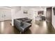 An open-concept living room, with a modern kitchen, a comfortable sofa, and hardwood floors at 10071 Yampa Ct, Commerce City, CO 80022