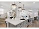 Open-concept kitchen featuring a large island with seating, modern fixtures, and easy access to the living spaces at 14998 Cast Pebble Cir, Parker, CO 80134
