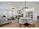 Bright and airy living room with a fireplace, plush seating, and open to the adjacent dining area at 14998 Cast Pebble Cir, Parker, CO 80134