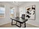 Modern home office with a sleek black desk, contemporary art, and natural light from multiple windows at 14998 Cast Pebble Cir, Parker, CO 80134