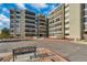 Apartment building exterior featuring balconies and ample parking, with seating in the front at 13901 E Marina Dr # 113, Aurora, CO 80014