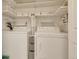 Bright laundry room with white appliances, built-in shelving, and plenty of storage space at 13901 E Marina Dr # 113, Aurora, CO 80014