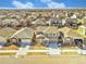 An aerial view shows the property in a neighborhood under a partly cloudy sky at 885 Hearthstone Ave, Brighton, CO 80601