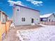 Exterior view of home showing door access to gravel patio and the yard, offering a private outdoor space at 885 Hearthstone Ave, Brighton, CO 80601
