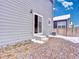 Exterior view of home showing door access to gravel patio and the yard, offering a private outdoor space at 885 Hearthstone Ave, Brighton, CO 80601