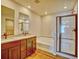 Well-lit bathroom with double vanity, soaking tub, and glass-enclosed shower at 885 Hearthstone Ave, Brighton, CO 80601