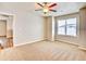 Bedroom features a ceiling fan, carpet, and a large window at 885 Hearthstone Ave, Brighton, CO 80601