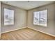Cozy bedroom with neutral carpet, two windows, and a view of a neighboring home at 885 Hearthstone Ave, Brighton, CO 80601