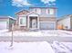Charming two-story home with stone accents, gray siding, and a two-car garage at 885 Hearthstone Ave, Brighton, CO 80601