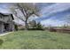 A sprawling green backyard with mature trees adjacent to the home's exterior and stone accents at 14993 W 55Th Dr, Golden, CO 80403