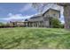 An expansive, well-maintained backyard featuring the home's exterior, mature trees, and a privacy fence at 14993 W 55Th Dr, Golden, CO 80403