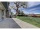 A well-manicured lawn with mature trees, a built-in grill, and stone accents on the home's exterior at 14993 W 55Th Dr, Golden, CO 80403
