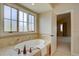 Bathroom featuring a jetted tub with tile surround, large windows, and natural light at 14993 W 55Th Dr, Golden, CO 80403