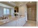 Bathroom featuring double sinks, granite countertops, and a tiled glass-enclosed shower at 14993 W 55Th Dr, Golden, CO 80403