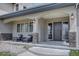 Inviting front porch with comfortable seating, stone pillars, and an elegant entry door creates a welcoming first impression at 14993 W 55Th Dr, Golden, CO 80403